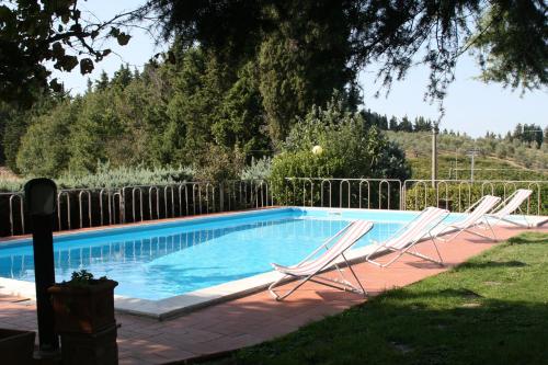 a group of chairs sitting next to a swimming pool at Holidays In The Heart Of Chianti in Tavarnelle Val di Pesa