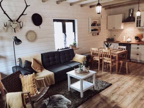 una sala de estar con un sofá y una mesa en Domki Nad Potokiem574067621, en Ustrzyki Dolne
