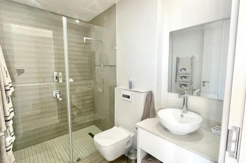 a bathroom with a toilet and a sink and a shower at Exclusive luxury & lifestyle suite in Mossel Bay