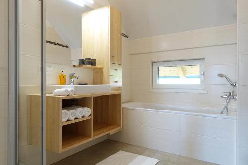y baño con ducha, bañera y lavamanos. en Apartment Landschitzseen, en Sankt Andrä im Lungau