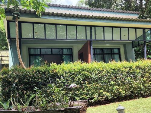 a house with glass windows and a garden at Snapper House in Khao Lak