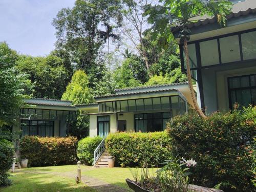 an exterior view of a house with bushes and trees at Snapper House in Khao Lak