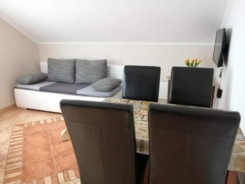 a living room with a couch and a table and chairs at Laci Apartman in Zalakaros