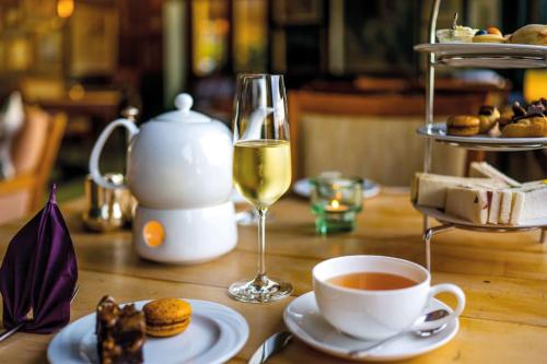 a table with a cup of tea and a glass of wine at Diehls Hotel in Koblenz