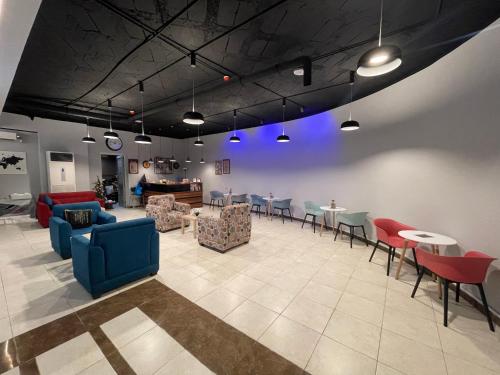 a living room with tables and chairs and a room with blue lights at Baden Hotel Suites in Amman