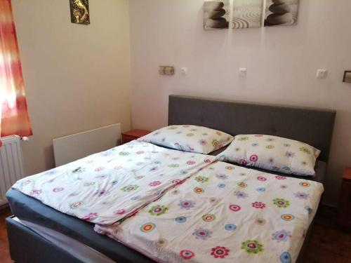 a bed with a blanket on it in a bedroom at Laci Apartman in Zalakaros