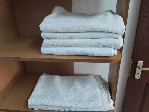 une pile de serviettes blanches sur une étagère dans l'établissement DINO 4, à Trou aux Biches