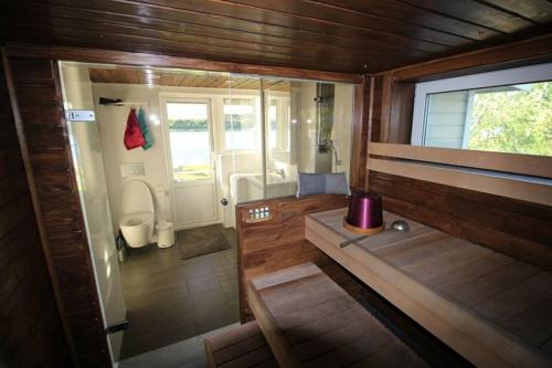 a small bathroom with a tub and a toilet at Beautiful riverside cottage with sauna in Nuorgam