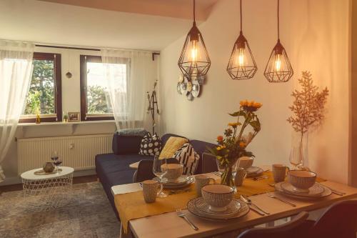 uma sala de estar com uma mesa e um sofá azul em Goldrausch - Glanzvolle Ferienwohnung in Meißen am Lutherplatz em Meissen