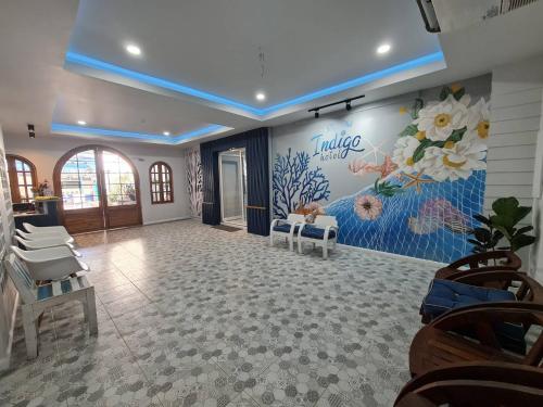 Phi Phi Indigo Hotel في جزيرة في في: غرفة انتظار مع جدارية من الزهور على الحائط