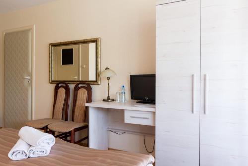 a bedroom with a bed and a desk and a mirror at Hotel Galicja in Ulanów