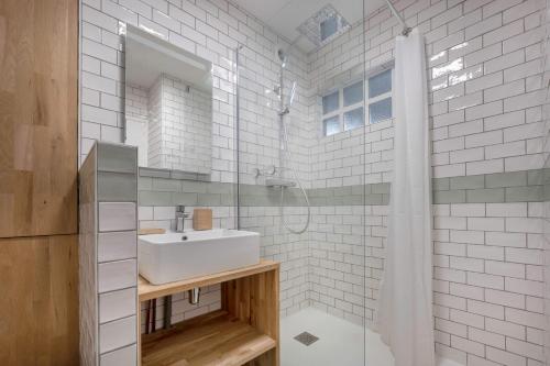 une salle de bain blanche avec un lavabo et une douche dans l'établissement Charmant appartement vue mer!, à La Baule