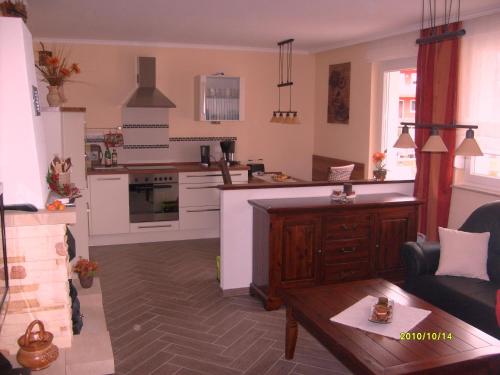 a kitchen and living room with a couch and a table at Apartment zum Dünenblick in Trassenheide