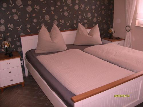 sypialnia z 2 łóżkami i białymi poduszkami w obiekcie Apartment zum Dünenblick w Trassenheide