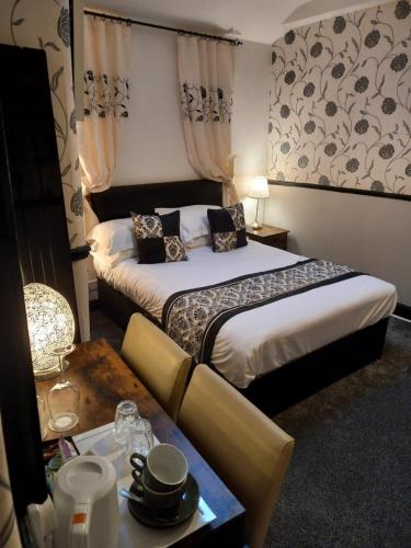 a hotel room with two beds and a table at Virginia Cottage Guest House in Bowness-on-Windermere
