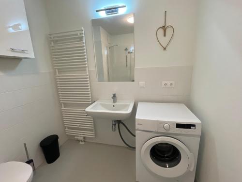 a bathroom with a washing machine and a sink at 55 m2 Stylish Apartment with Balcony and Netflix in Vienna