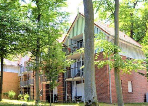 a red brick building with trees in front of it at Ferienwohnung Seepferdchen direkt am Strand in Ostseebad Koserow