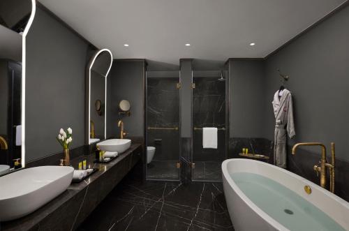 a bathroom with two sinks and a tub and a shower at Hyatt Centric Sector17 Chandigarh in Chandīgarh