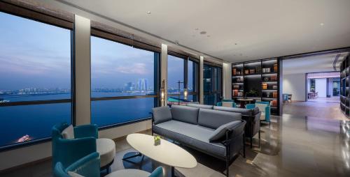 a living room with a couch and chairs and windows at InterContinental Suzhou Hotel by IHG in Suzhou