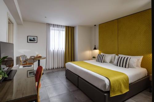 a hotel room with a large bed and a television at Urban Rooms by NEU Collective in Il-Gżira