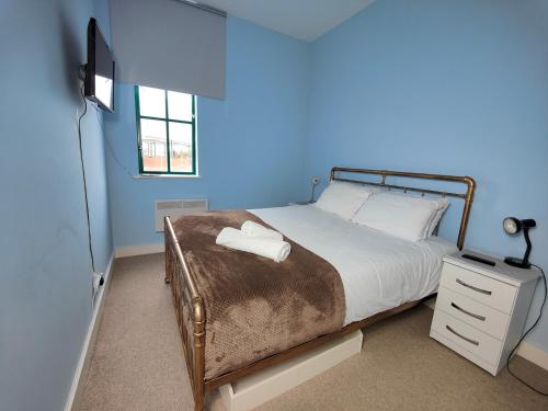 a bedroom with a bed and a blue wall at Pass the Keys Spacious Apartment Minutes to Birmingham Centre in Birmingham