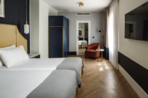 a hotel room with a bed and a chair at The Cumberland by NEU Collective in Valletta