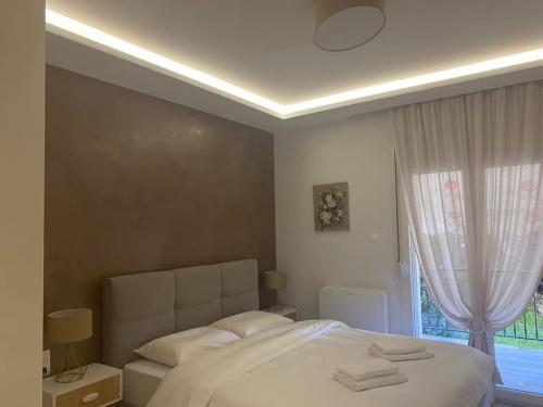 um quarto com uma grande cama branca e uma janela em Apartment by the castle em Ioannina