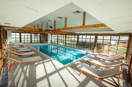 a pool with lounge chairs and a swimming pool at ETNO SELO VRANEŠA Zlatar in Nova Varoš