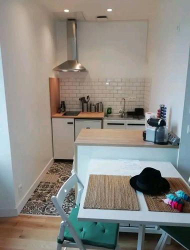 - une cuisine avec une table et un chapeau dans l'établissement Le Cocon d'Aguilera à 200m du stade et 2km de la plage, à Anglet