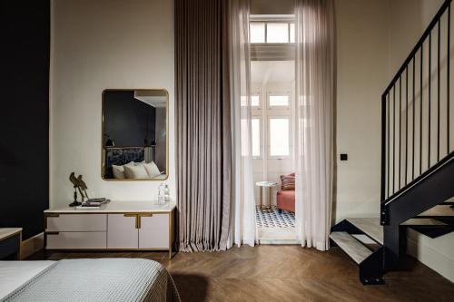a bedroom with a bed and a mirror at The Cumberland by NEU Collective in Valletta