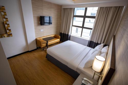 a hotel room with a bed and a window at Citrus Hotel Johor Bahru by Compass Hospitality in Johor Bahru