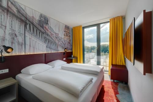 a bedroom with two beds and a large window at Campanile Muenchen Sendling in Munich
