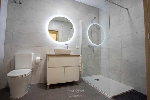 ein Badezimmer mit einem WC, einem Waschbecken und einem Spiegel in der Unterkunft Casa Rural Namasté con SPA in Lleida