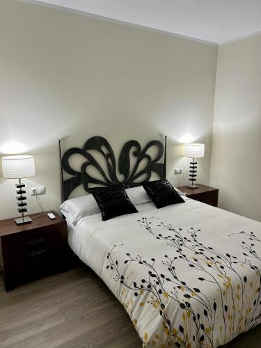 a bedroom with a black and white bed with two lamps at Casa Rural Namasté con SPA in Lleida