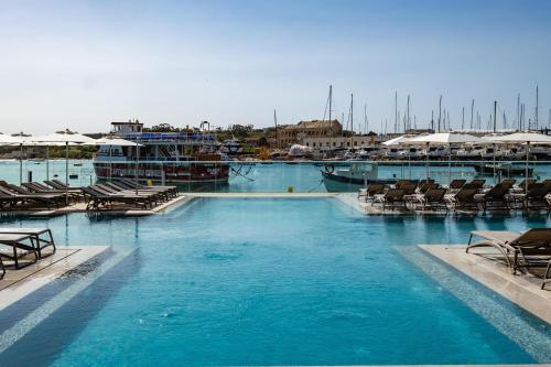 a large swimming pool with chairs and a marina at Urban Rooms by NEU Collective in Il-Gżira