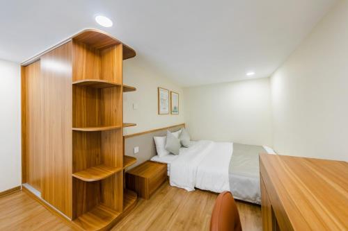 a bedroom with a bed and a book shelf at Five Star Westlake 1st-4th Floors Hotel & Serviced Apartment in Hanoi