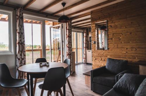 un salon avec une table et des chaises dans l'établissement Le Village de Cottages - Le Pôle du Cheval et de l'Âne, à Lignières