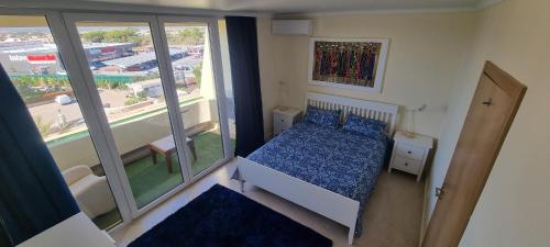 um pequeno quarto com uma cama e uma varanda em T2+1 - Sousa Vila - Apartament with the best pool @ Algarve em Alvor