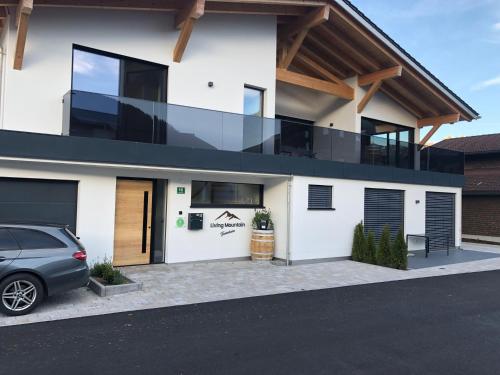 a house with a car parked in front of it at Living Mountain Tannheim in Tannheim