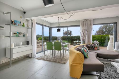 un salon avec un canapé et une table avec des chaises dans l'établissement Maison d’Architecte Face Mer à la Plaine sur Mer, à La Plaine-sur-Mer