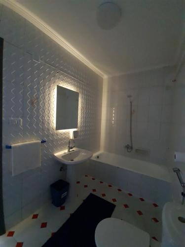 a bathroom with a sink and a toilet and a tub at Nour 1 in Alexandria