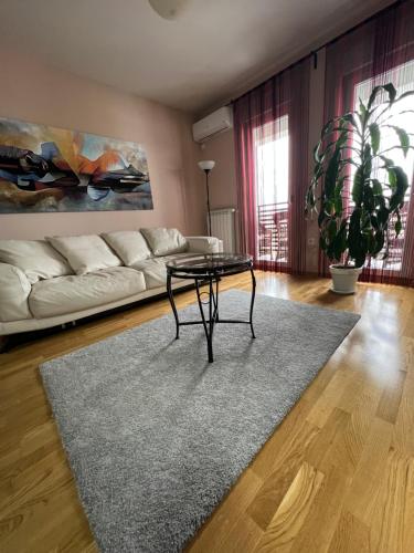 ein Wohnzimmer mit einem Tisch und einem Sofa in der Unterkunft Studio Bauhaus in Čačak