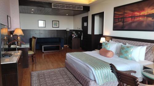 a hotel room with a large bed and a desk at Fortune Park Moksha, Mcleodganj - Member ITC Hotels' Group in McLeod Ganj