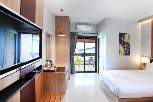 a bedroom with a bed and a flat screen tv at Avarin Resort in Pak Chong