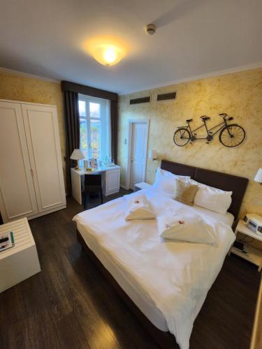 Hotel Millennium في لوكارنو: غرفة نوم مع سرير ودراجة على الحائط