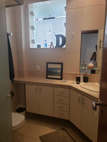 y baño con lavabo, espejo y aseo. en Lindo apartamento top Copacabana luxo, en Río de Janeiro