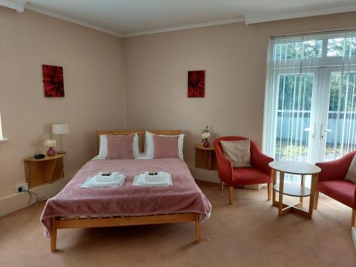 a bedroom with a large bed and two chairs at Cripps Annexe in Nottingham
