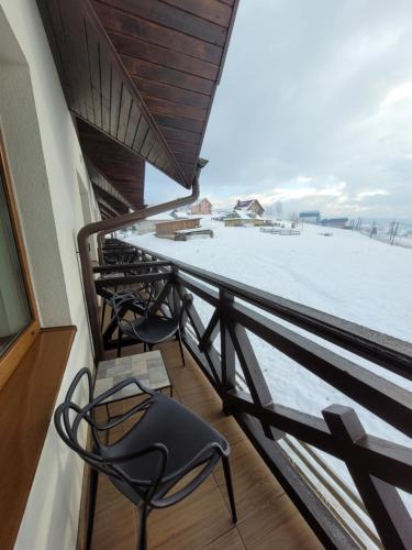 a balcony with two chairs and a view of the snow at Zaporizʹka Sich in Bukovel