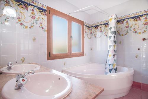 a white bathroom with a tub and a sink at Villa Ibiza - PlusHolidays in Calpe