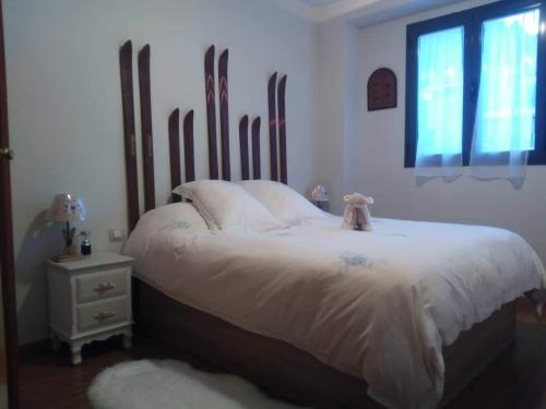 een slaapkamer met een bed met witte lakens en een raam bij Apartamento Riglos Candanchu in Candanchú